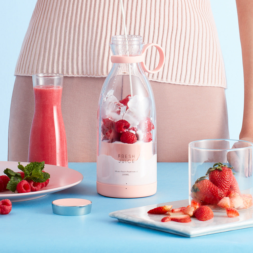 Bottle of fresh juice with strawberries and raspberries on a blue background